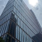 141 Willoughby Street, a glass curtain-wall office tower in Downtown Brooklyn, photographed from street level looking up.