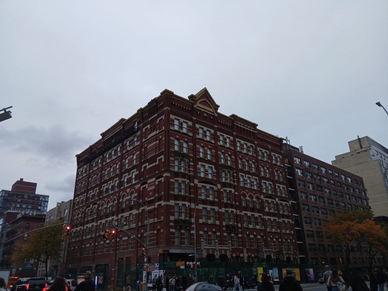 Red-brick apartment buildings at a Hell's Kitchen intersection, October 2025