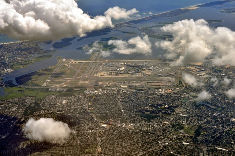 Aerial view of JFK Airport with Southeast Queens neighborhoods in the foreground and Jamaica Bay beyond
