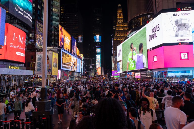 Crowds and digital billboards in Times Square at night